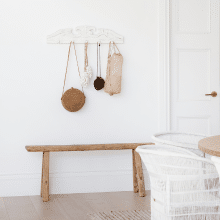 A modern coastal interior showing a timber bench seat against a white wall featuring Intrim SK58 skirting and architrave.