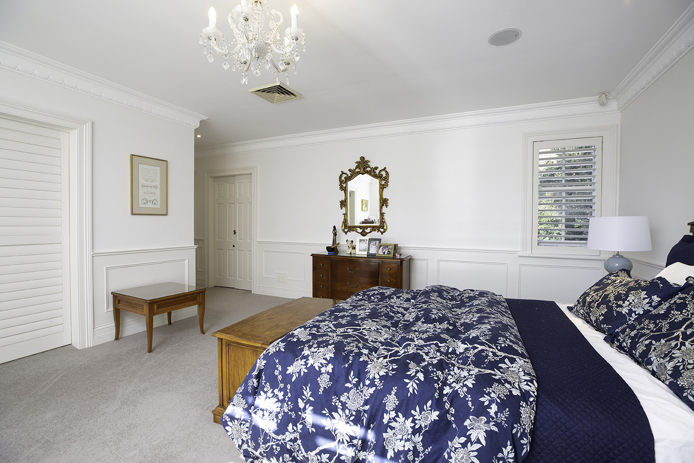 Classic bedroom featuring paired-back wainscoting with simple rectangular moulding panels