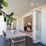 Modern alfresco area with dining setting and VJ style ceiling featuring Intrim's tongue and groove lining boards in white finish