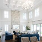 Modern Hamptons-style Indah Island Coolbinia large, open plan living space with high ceilings, grey stone accent wall, and feature chandelier