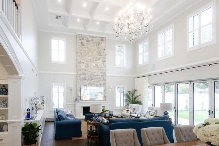 Modern Hamptons-style Indah Island Coolbinia large, open plan living space with high ceilings, grey stone accent wall, and feature chandelier