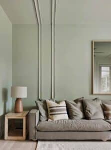A styled lounge room with olive green painted walls featuring Intrim WB43 battens on the wall and ceiling