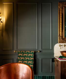 Intrim CR280 chair rail moulding creating elegant wall panelling in a luxury bathroom with dark green walls, decorative mouldings, timber vanity and copper basin.
