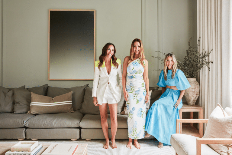 Three women standing proudly in a stylishly renovated lounge room