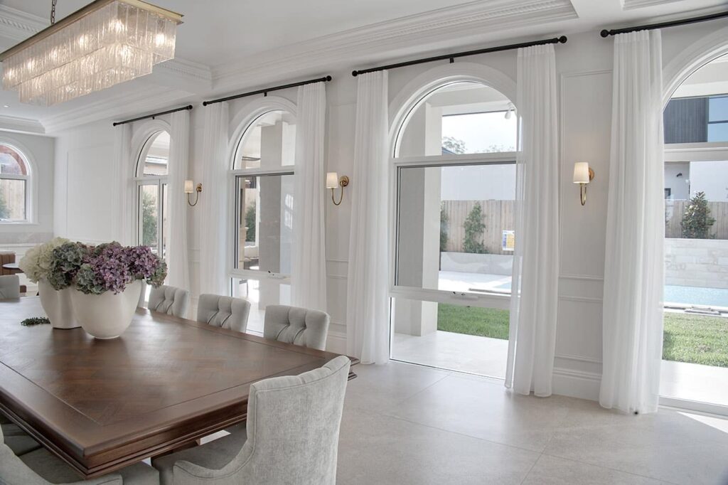 Four, full-length arched windows with curved architraves