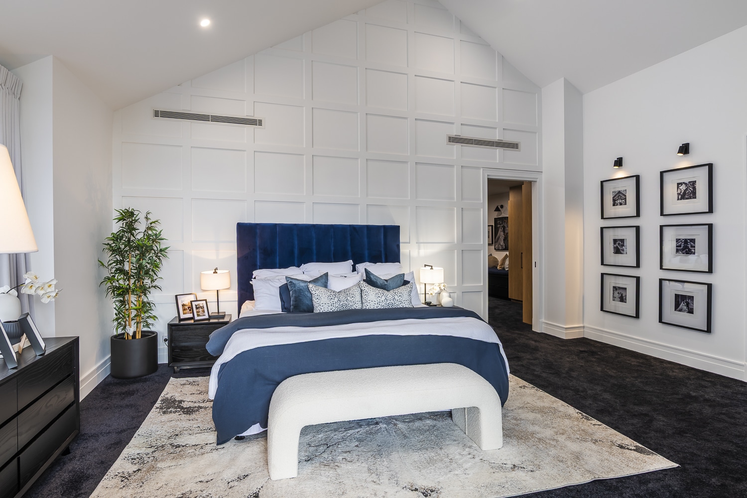 Contemporary bedroom featuring full-height wall panelling grid design with decorative timber mouldings and classic skirting detail