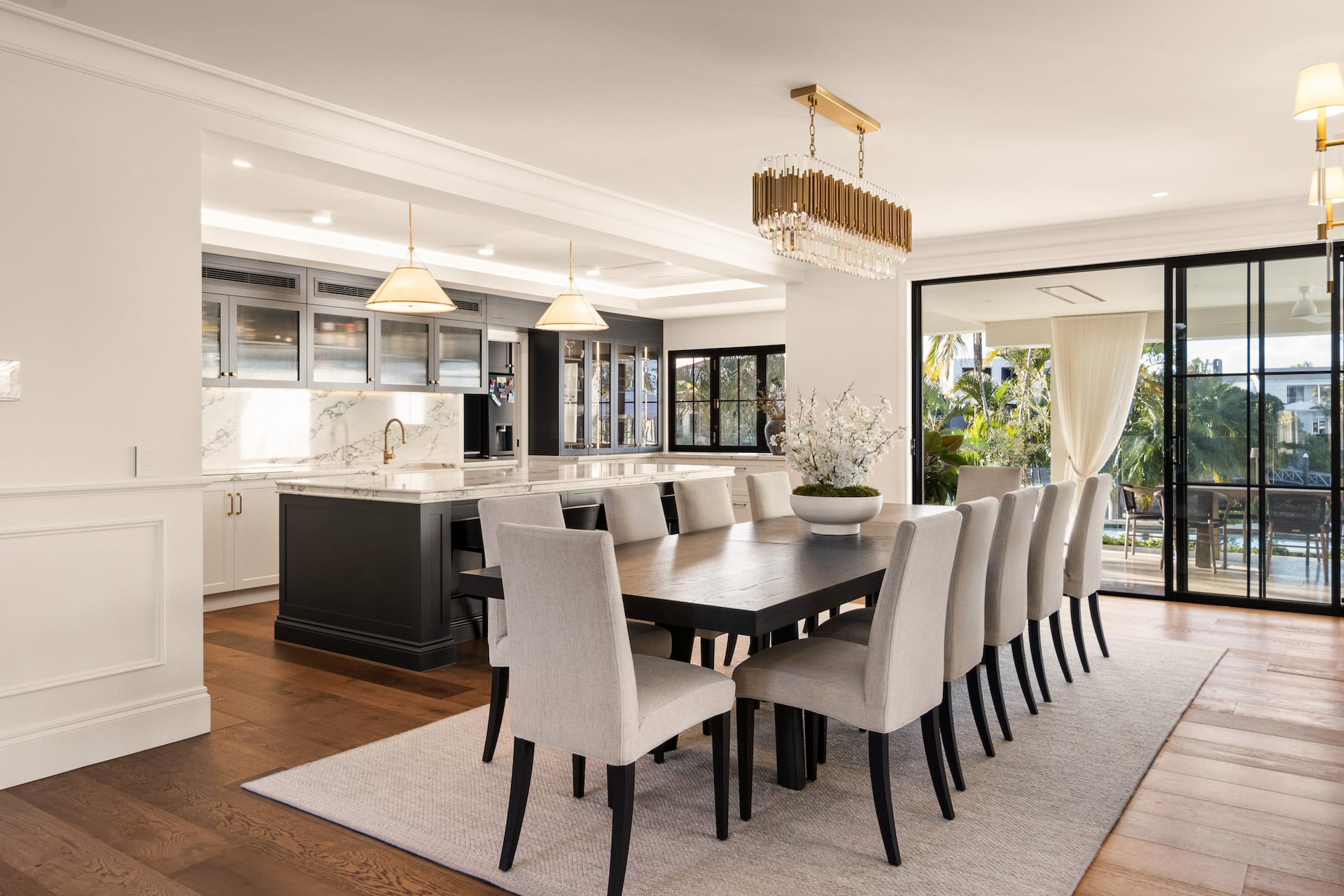 Open-plan dining and kitchen space featuring decorative timber mouldings, detailed cornice, wall panelling, and coffered ceiling design in a luxury Australian home