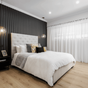 Modern Art Deco-style bedroom with vertical black wall panelling behind a large bed with black, white, and gold cushions