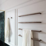Bathroom with brass fixtures, and wainscoting—mouldings frame the space with classic proportions and tactile charm.
