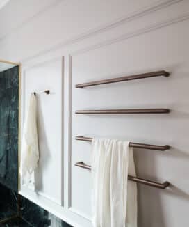 Bathroom with brass fixtures, and wainscoting—mouldings frame the space with classic proportions and tactile charm.