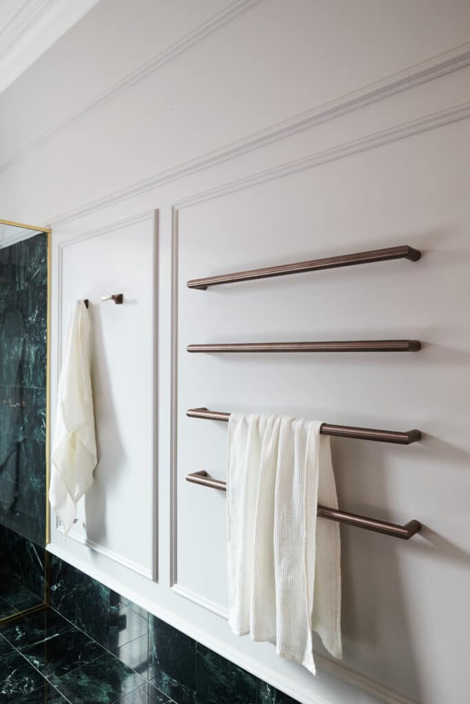 Bathroom with brass fixtures, and wainscoting—mouldings frame the space with classic proportions and tactile charm.