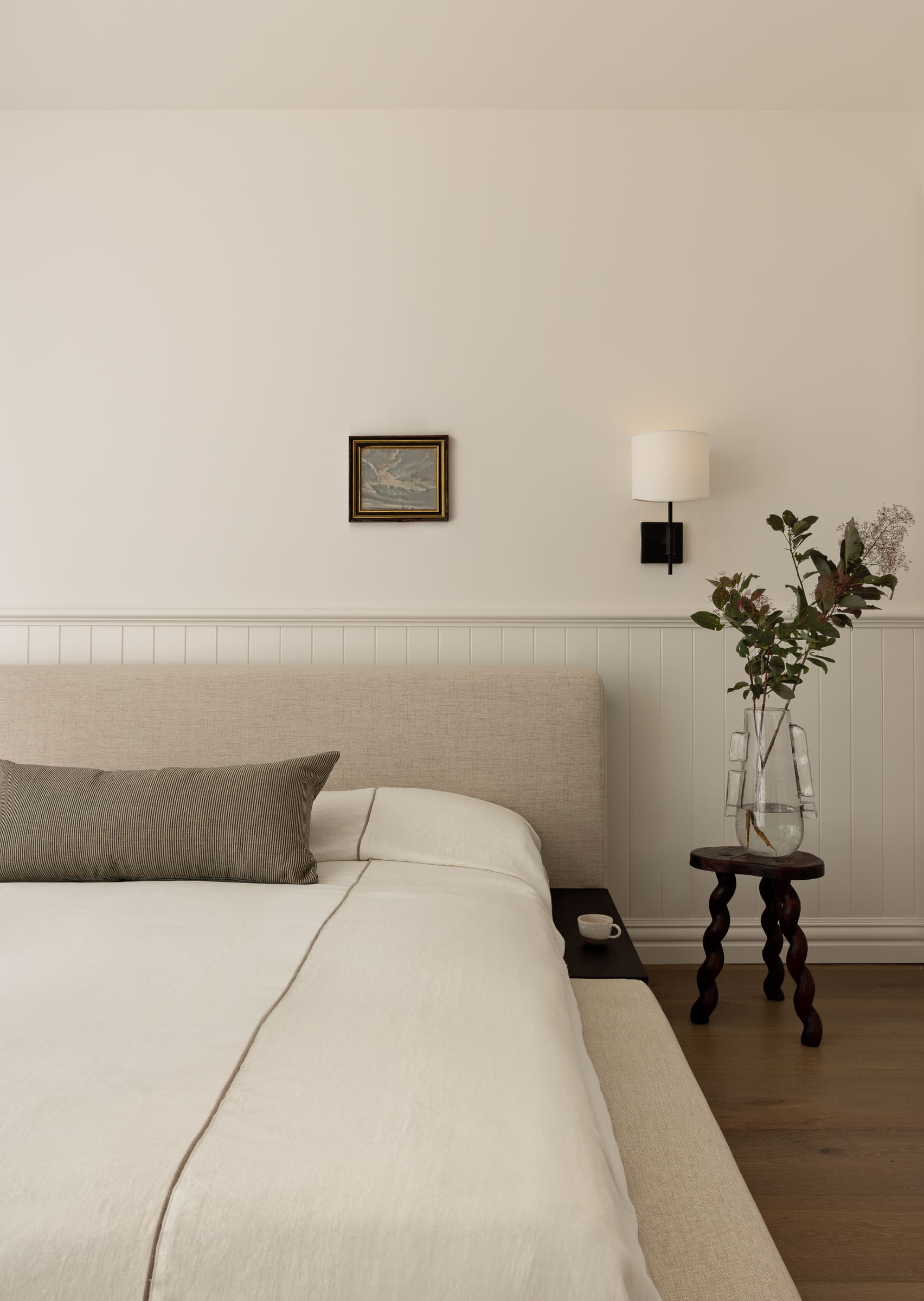 Bedroom featuring half-height wall panelling with dado rail detail, timber skirting boards, and soft neutral interior styling.