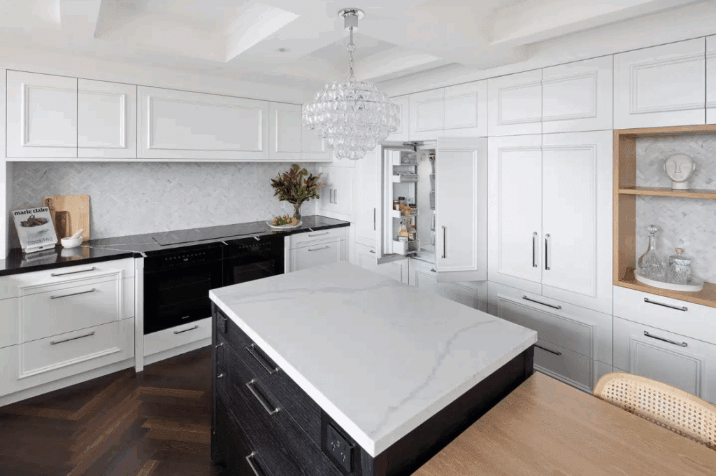 Modern Contemporary kitchen with white cabinetry and cooking island featuring contrasting black and white marble worktops.