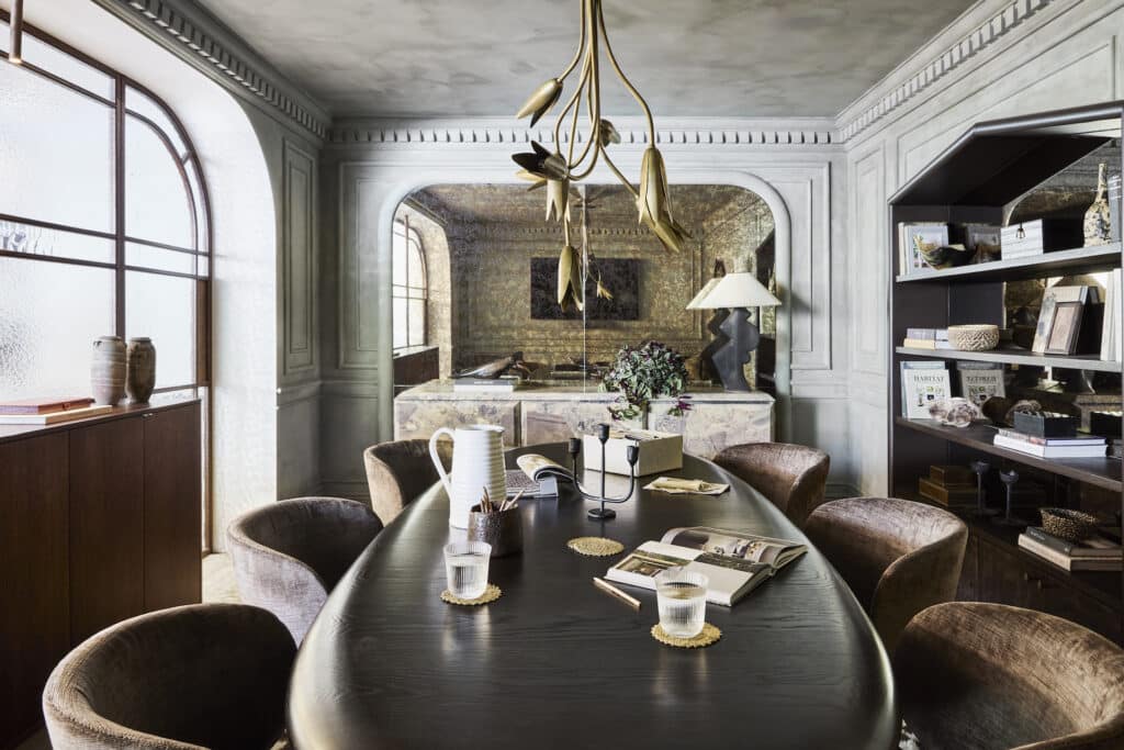 A stylish office with a dark wood boardroom table and decorative timber mouldings adorning the limewashed walls.