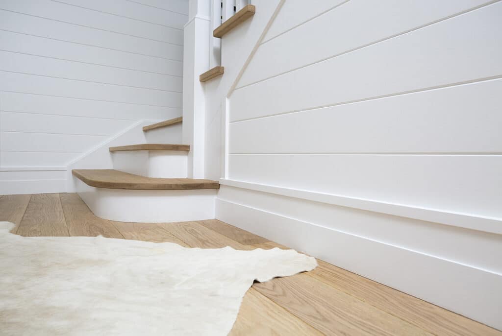 Shiplap style wainscoting accenting a a wooden staircase