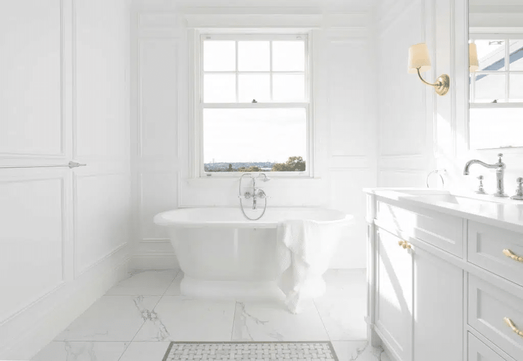 Wainscoting used to stylish effect in an open, white interior bathroom design