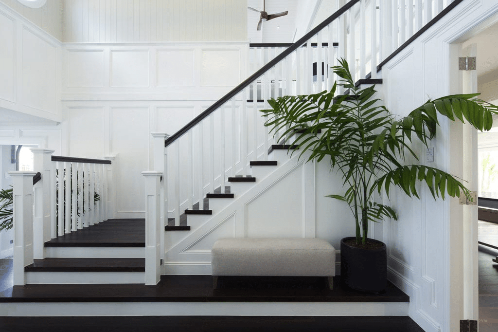 Stylish flat panel wainscoting alongside a black and white staircase