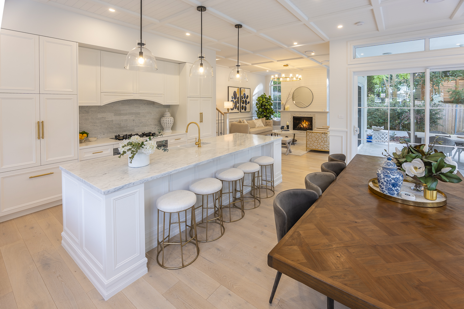 Classic kitchen featuring decorative island panelling, coffered ceiling detail, and refined cornice mouldings in a light-filled Australian interior.