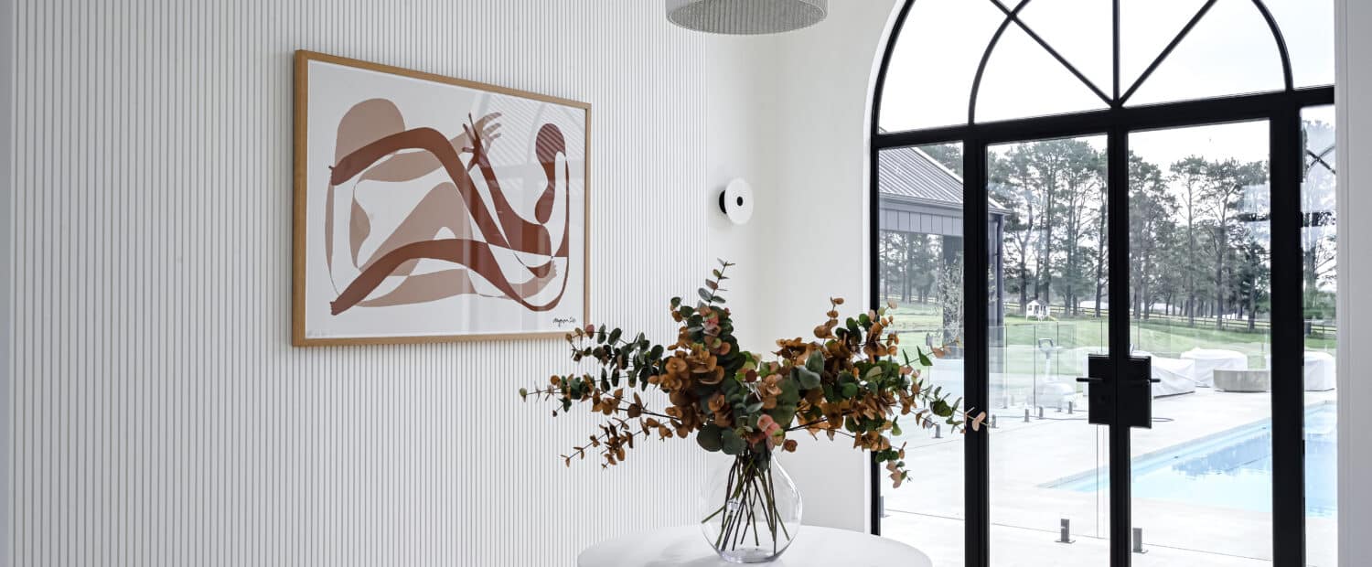 Farmhouse entry space with arched steel-framed doors, decorative wall panelling and Intrim SK1474 skirting.