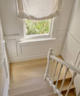 Stair landing with classic window sill nosing and wainscoting in Victorian terrace renovation by Convict Interiors using Intrim mouldings