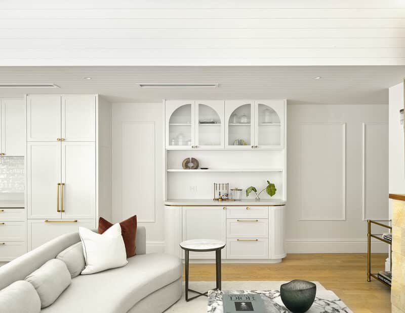 Light-filled open-plan living space with custom white joinery, marble coffee table, vaulted ceiling and Intrim SK110 skirting and architraves.