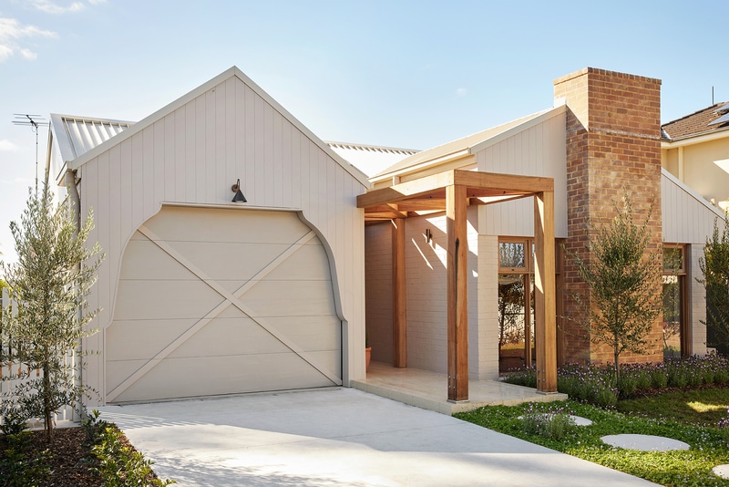 Front exterior of Maison Soleil featuring curved architectural details, vertical cladding and classic French Country-inspired design.