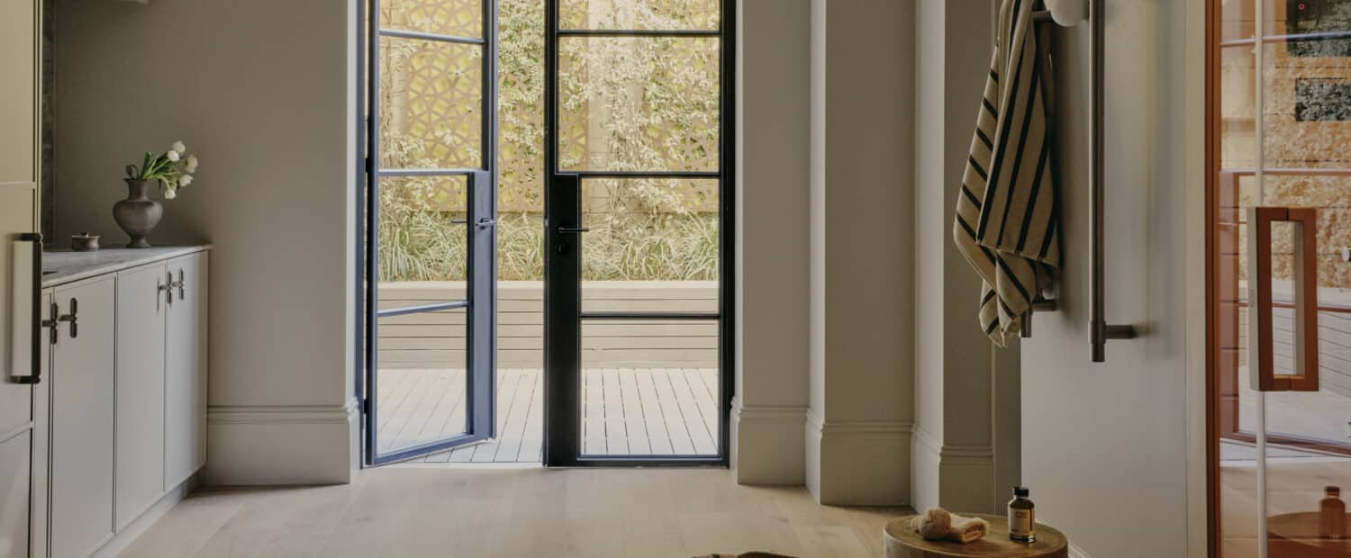 Terrace wellness floor renovation with tall skirting and steel-framed garden doors.