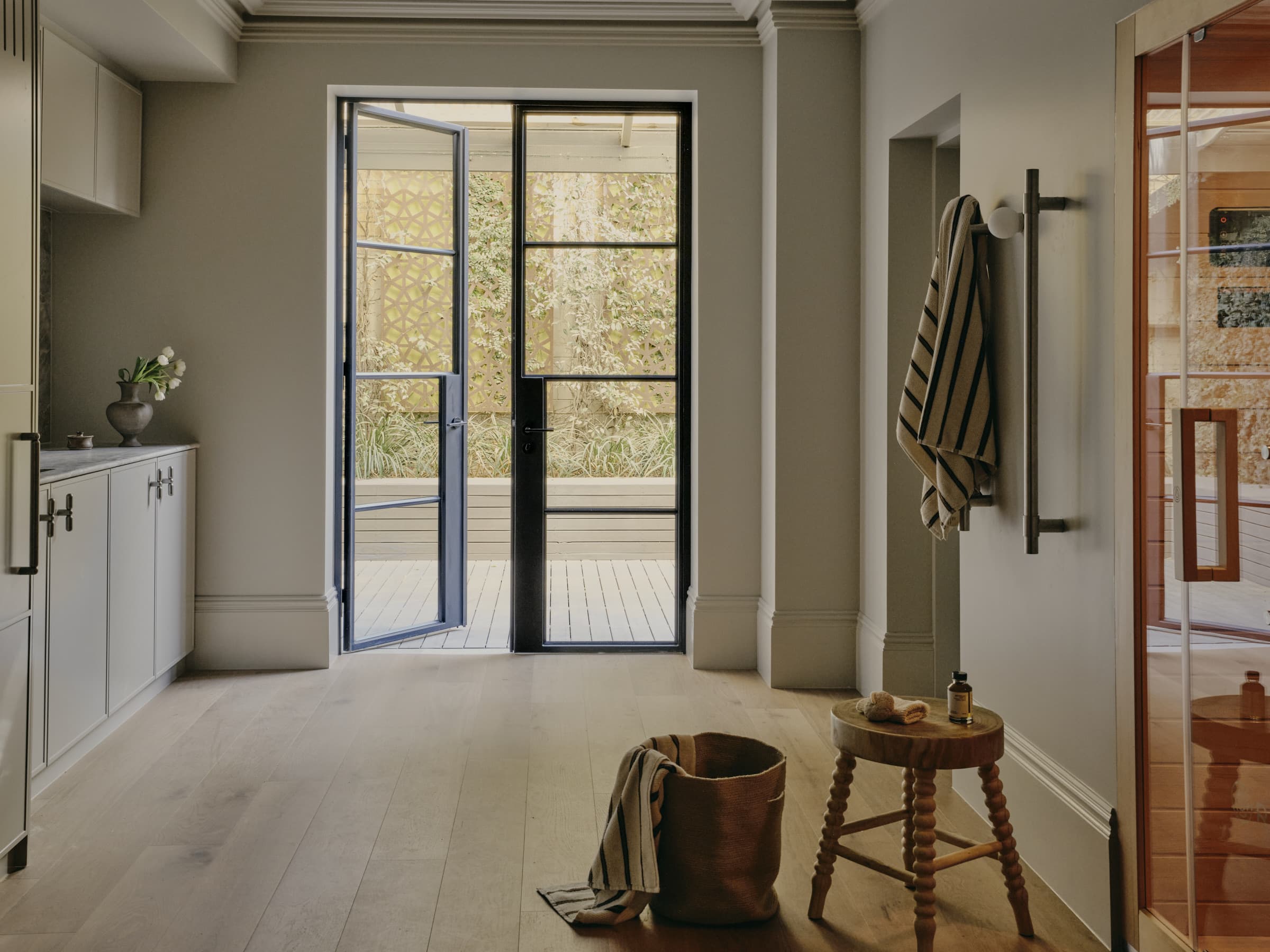 Terrace wellness floor renovation with tall skirting and steel-framed garden doors.