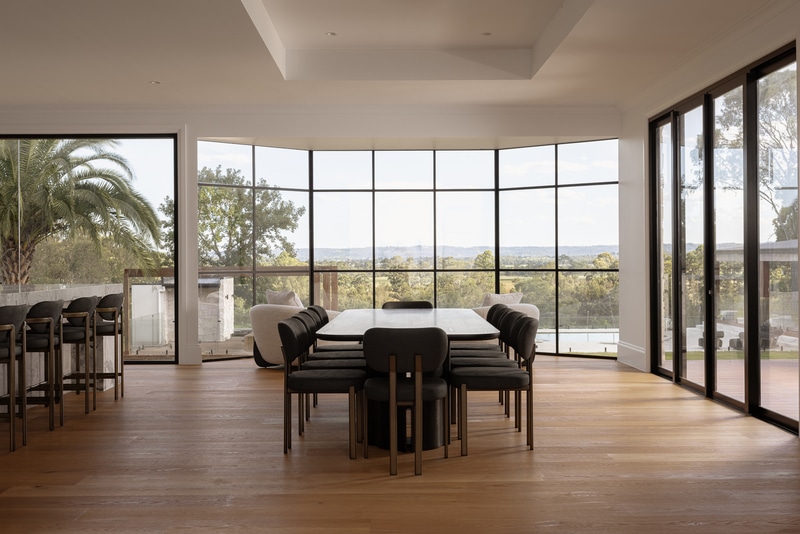 Open-plan dining room with expansive glazing and contemporary farmhouse design overlooking rural Cobbitty views