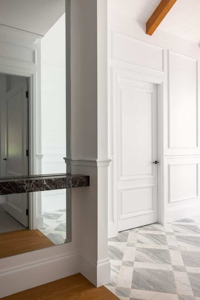 Entry detail showing Intrim SK498 architraves, decorative wall panelling and patterned stone flooring